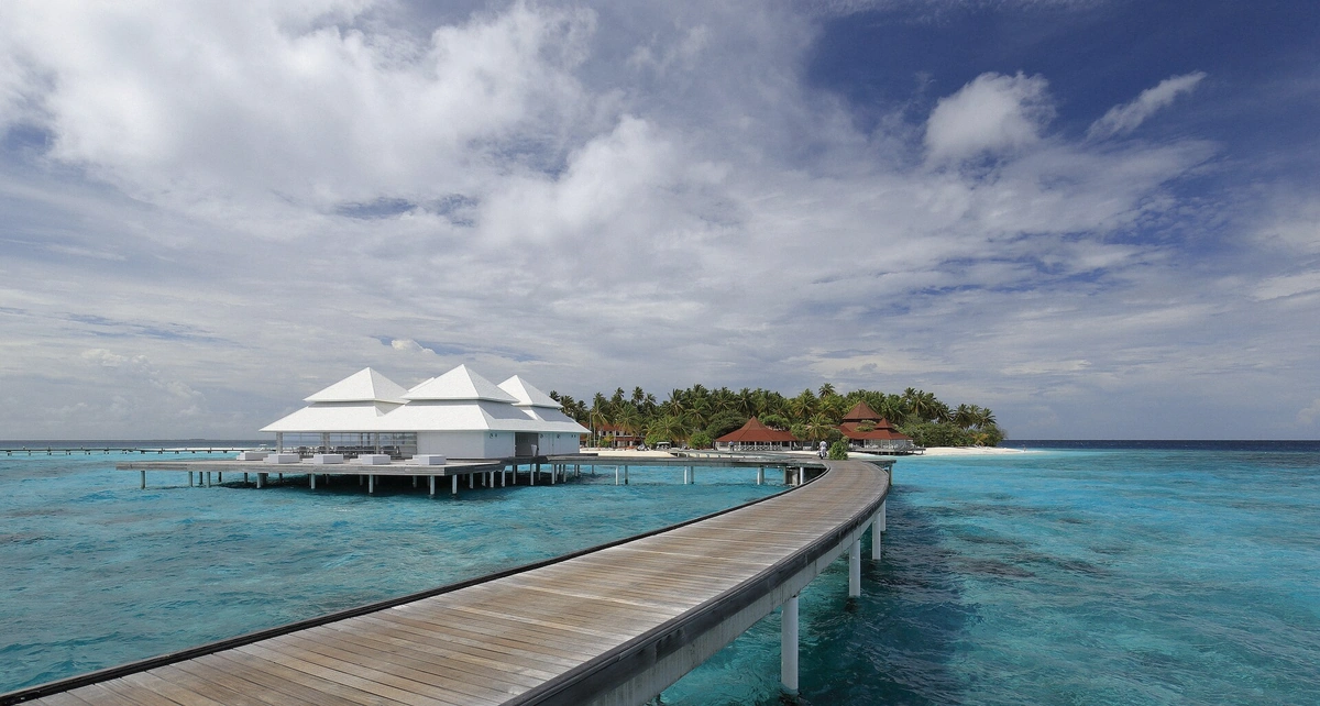 Row of overwater bungalows standing over the turquoise Bora Bora lagoon with house reef below, French Polynesia